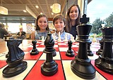 Leo Grace, 7, and sisters Sophia and Serena will be in the Barn Burner Chess Tournament on Saturday