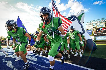 Asher Knopik and Jack Robinson lead the Glacier Wolfpack onto the field before their matchup with Helena Capital at Legends Stadium on Friday, Sept. 19. (Casey Kreider/Daily Inter Lake)