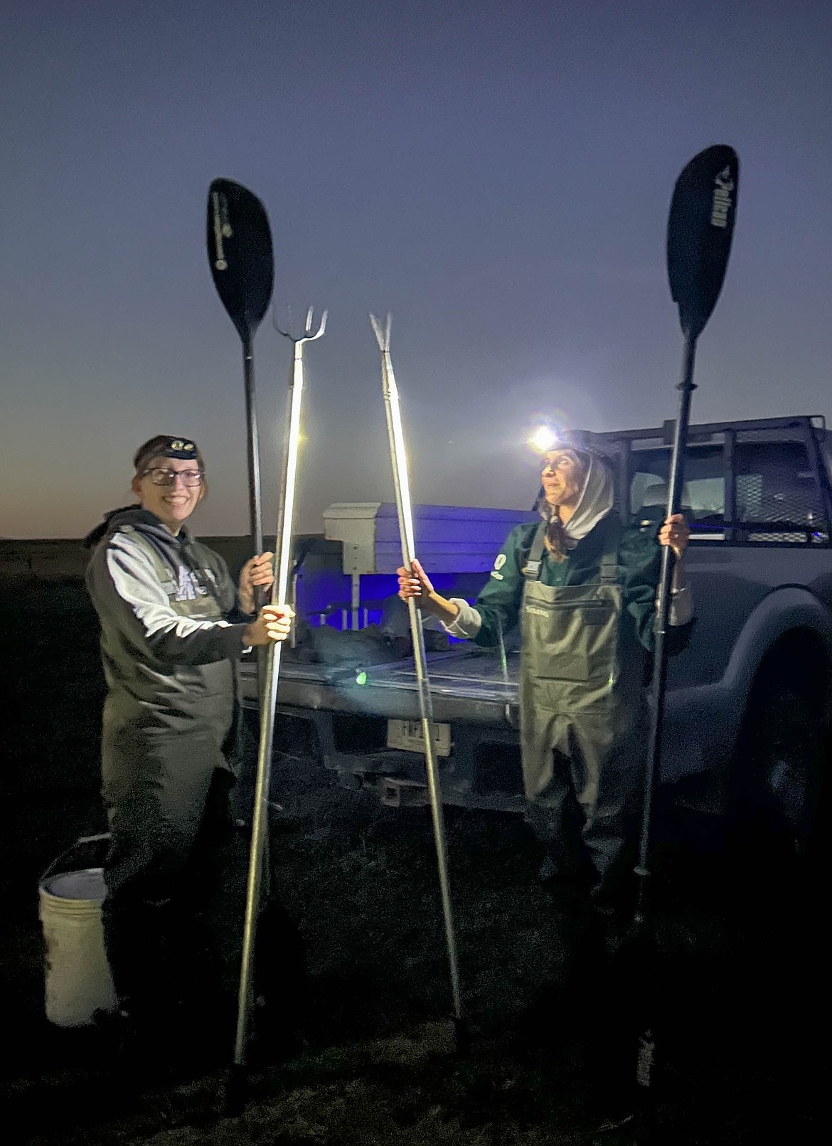 Brianna Rentschler and Amanda Emmel hold their frog gigs and paddles. They each take kayaks out onto the water and will spear bullfrogs as they see them. (Emily Messer/Leader)