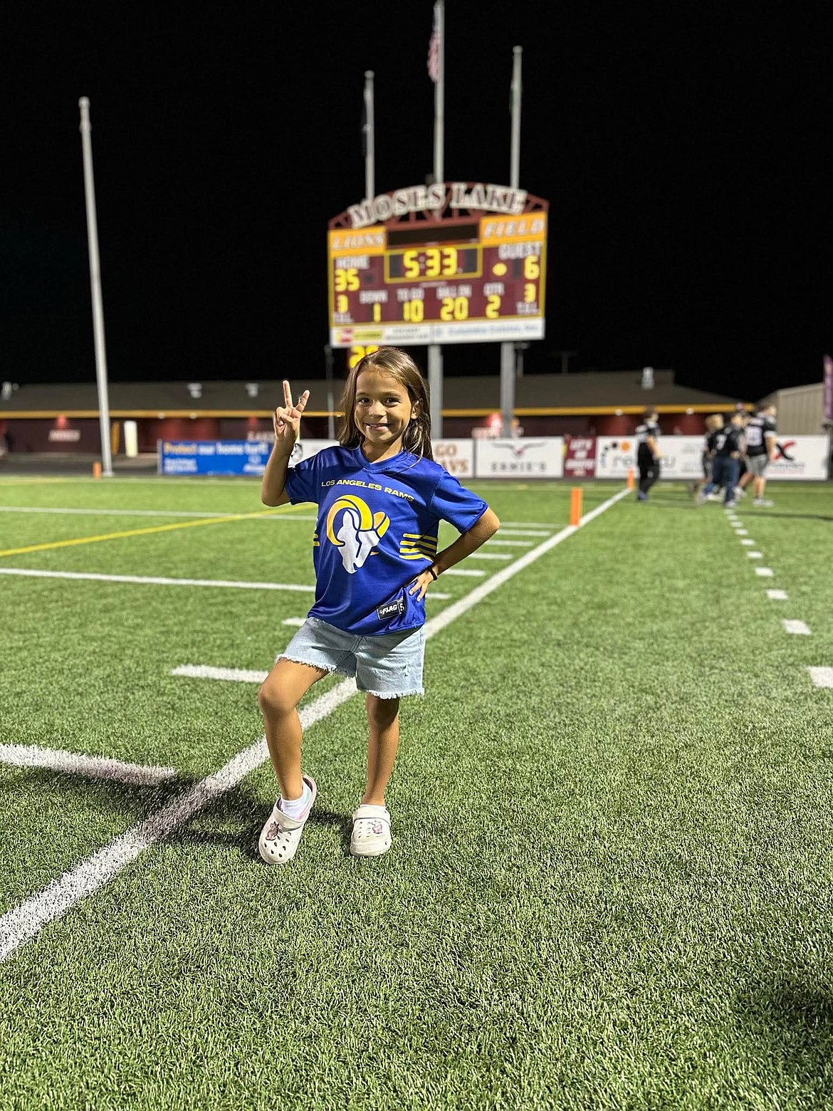 Jamisyn Martinez stands in front of the scoreboard at Lions Field after playing in a flag football game with the Grid Kids. Grid Kids administrator Brian Gwinn said the program has played co-ed football in the past, especially with the younger teams, but now has brought more girls into the program.