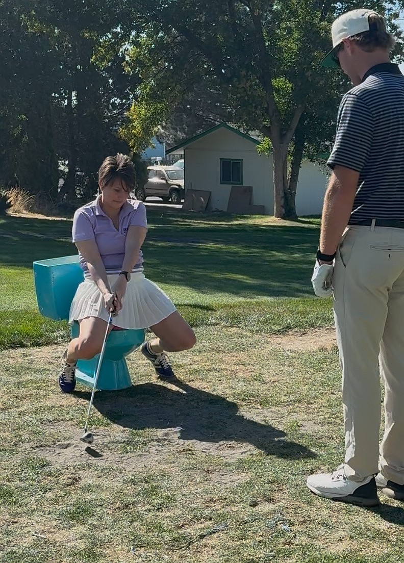 Karisti Cox, seated, takes a swing at the “Life is like a box of chocolates,” challenge. Cox organized the third annual “Dude! Where’s my Cart!?” charity golf tournament to raise awareness for Alzheimer’s.