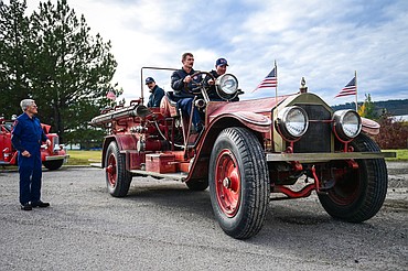 Retired firefighter and Kalispell Fire Department historian Alan “Gus” Gustafson, left, gives a few last minute driving instructions to firefighters Don Thibert, Ben Graham and Jake Felts before they take the department's 1925 American LaFrance fire engine for a spin during a demonstration in Kalispell on Friday, Oct. 3. (Casey Kreider/Daily Inter Lake)
