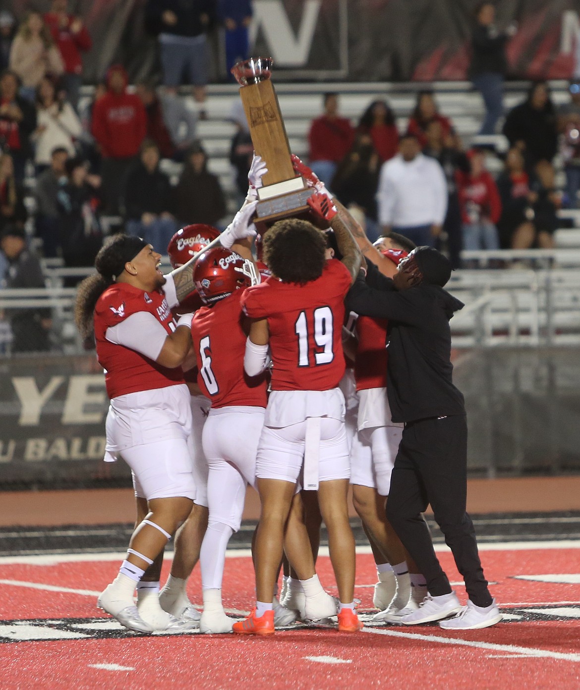 The Eagles celebrate with the Dam Cup after defeating the Portland State Vikings 35-27 on Saturday. Quarterback Nate Bell said a great week of practice led to their success over the Vikings.