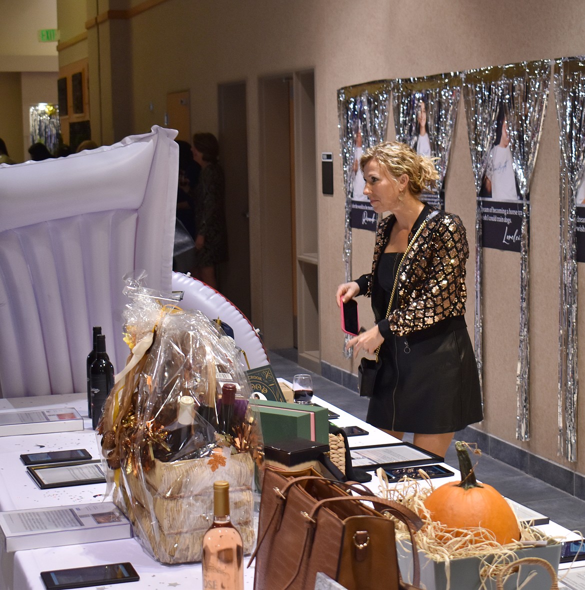 Corrisa Conner of Moses Lake looks over silent auction items at the Boys & Girls Club auction Saturday.