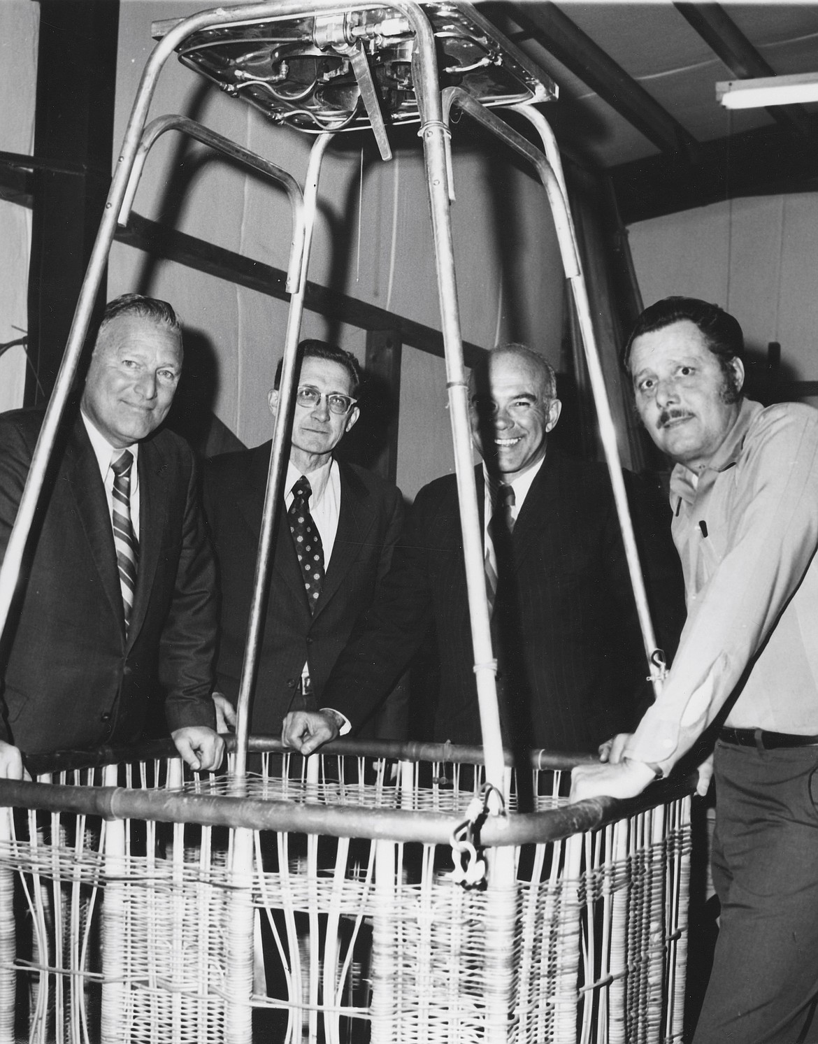 Mark Semich, owner and founder of Semco Balloon, stands with FAA personnel around a hot air balloon basket.