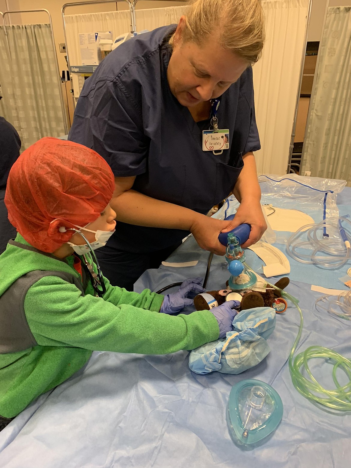 A child and medical professional work together to help a stuffed animal "breathe" during the Teddy Bear Clinic through Kootenai Health.