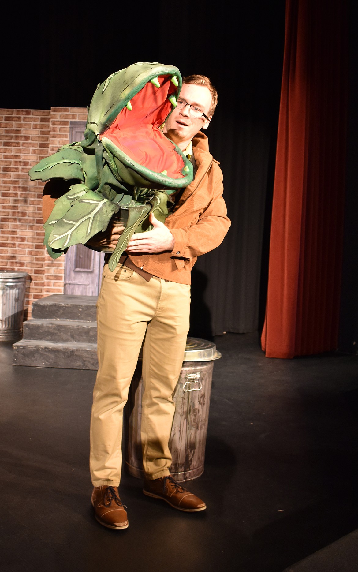 Taggart Hodges, right, displays a medium-sized Audrey II, the leafy, carnivorous villain of “Little Shop of Horrors,” opening Oct. 16.