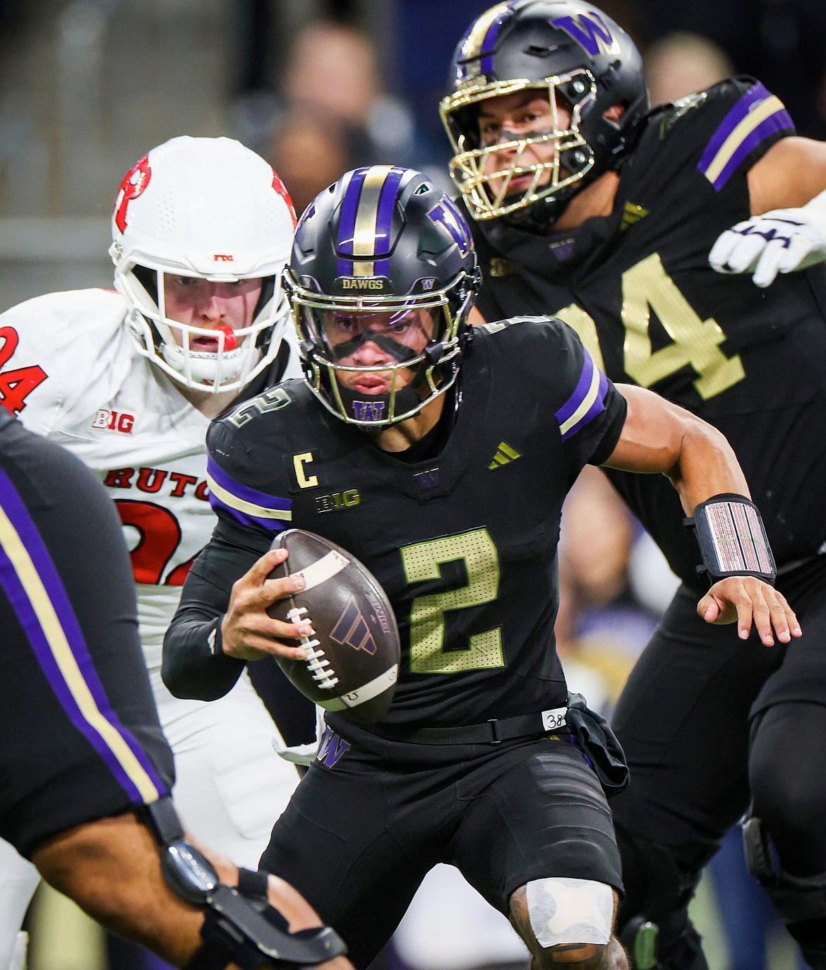 Washington quarterback Demond Williams Jr. (2) tries to escape a collapsing pocket but ends up sacked in the first half of an NCAA college football game against Rutgers, Friday, Oct. 10, 2025, in Seattle.