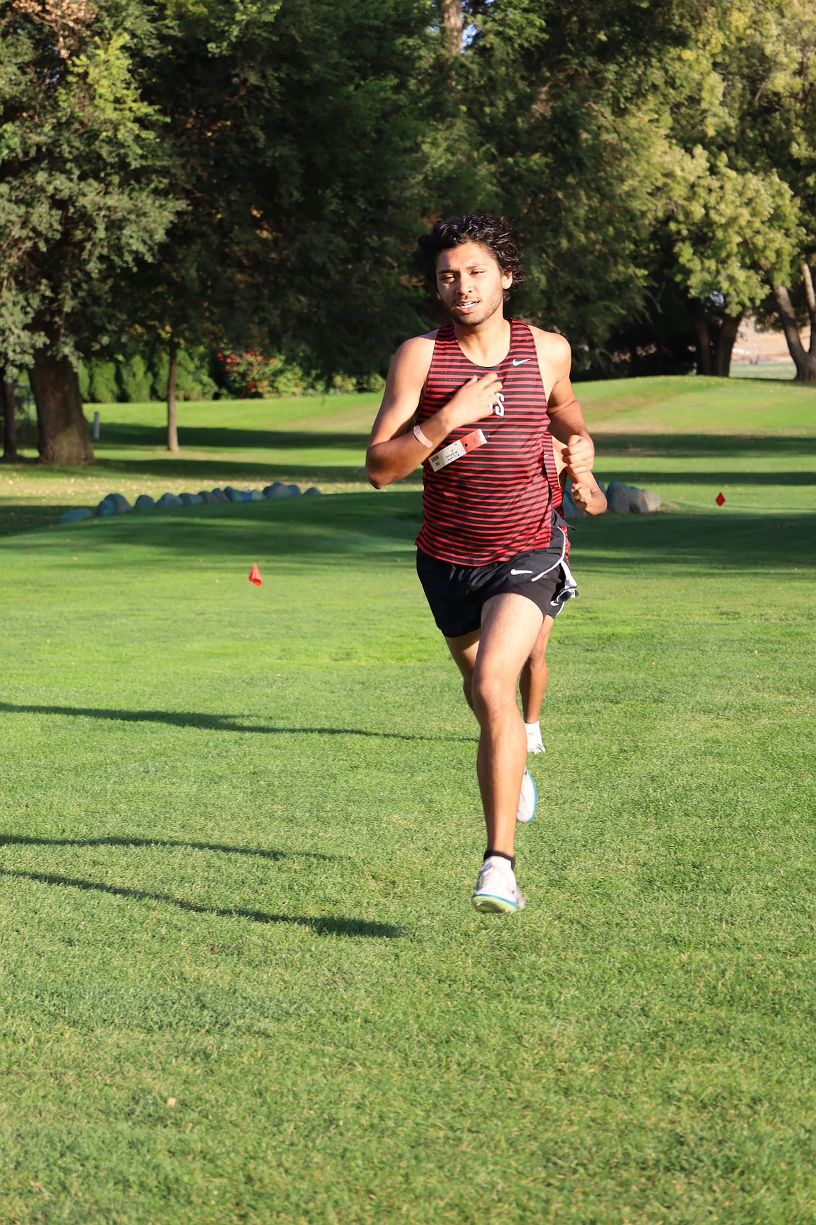 Huskies runner Alejandro Mendoza runs through the open field during the Max Jensen Invitational. Mendoza finished the course with a time of 17:09.48.