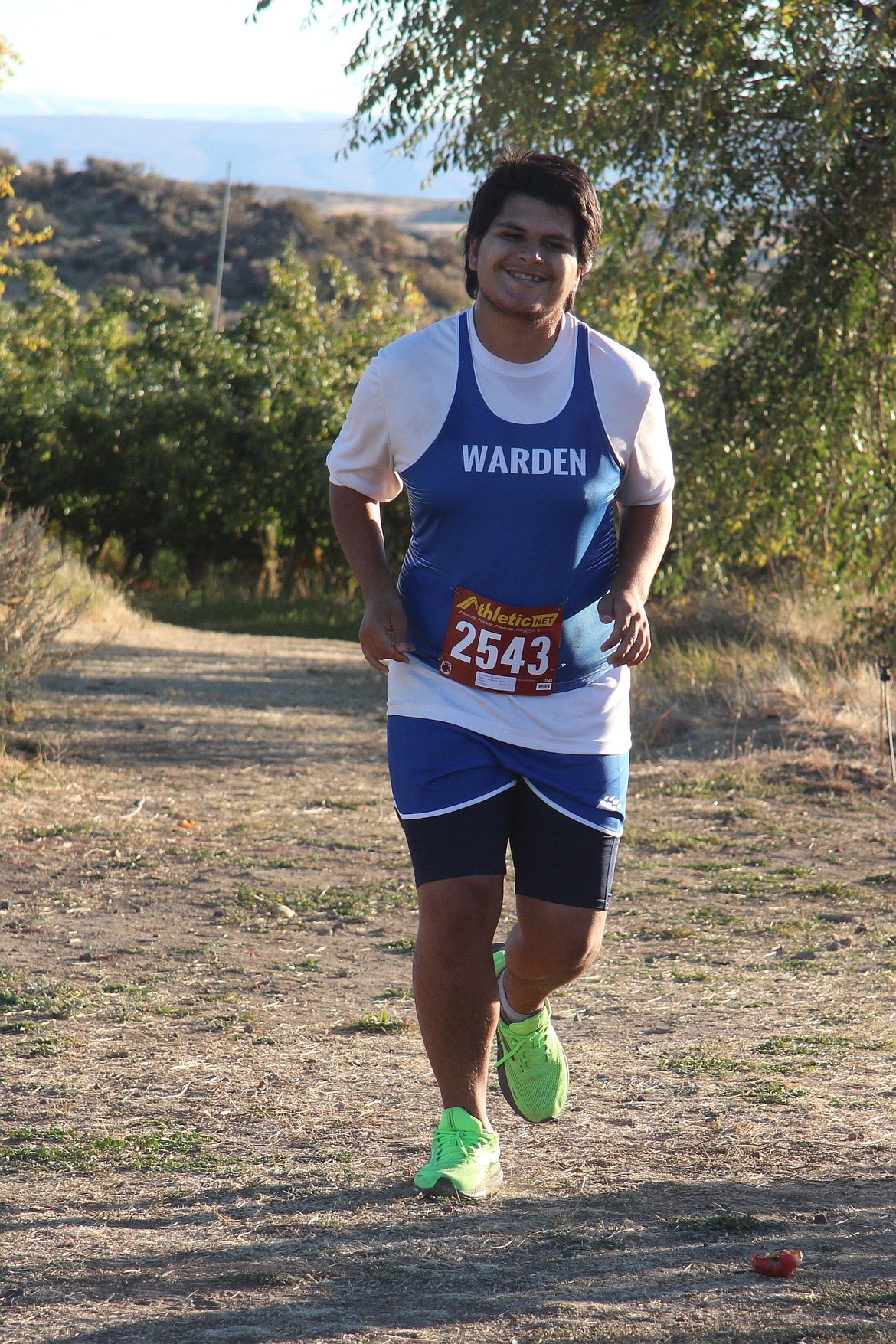 Enrique Gutierrez from the Cougars keeps up high spirits as he makes his way along the path at Apple Ridge. Gutierrez finished the three-mile with a time of 35:42.45.