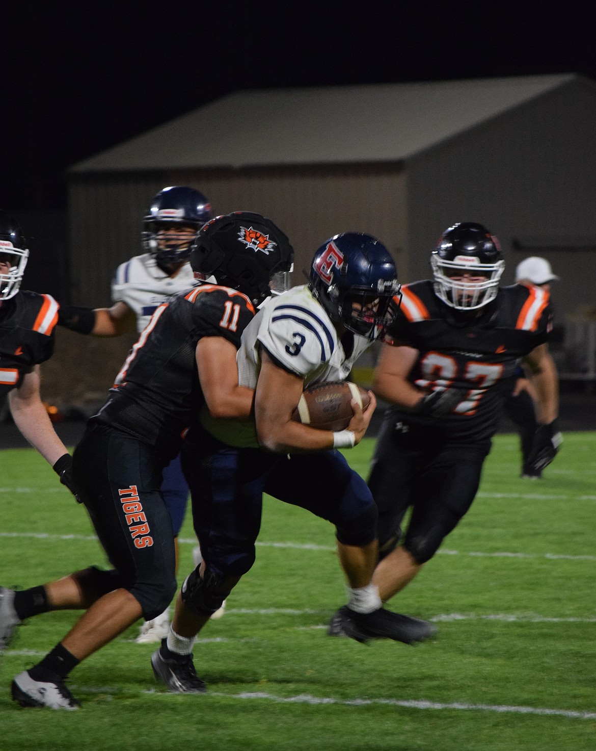 Tigers senior Calvin Lybbert (11) wraps himself around a player from Ellensburg while Tigers junior Own Fitch (87) closes in to secure the defensive stop earlier this season. The Tigers had a successful defensive game against Toppenish securing three interceptions and holding their opponent scoreless.