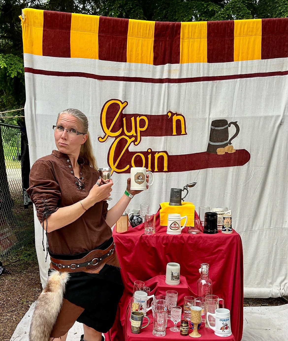 Ellen Fredrickson, a merchant from Darkest Night Candles, is seen at the Cup 'n Coin tankard booth at the Sandpoint Ren Faire in June. In a game of Cup 'n Coin, a player gives $1 for a coin, then tosses the coin toward the cups/tankards to potentially buy a tankard or faire cup. This is one example of the activities that will be at Echoes of Lore next spring.