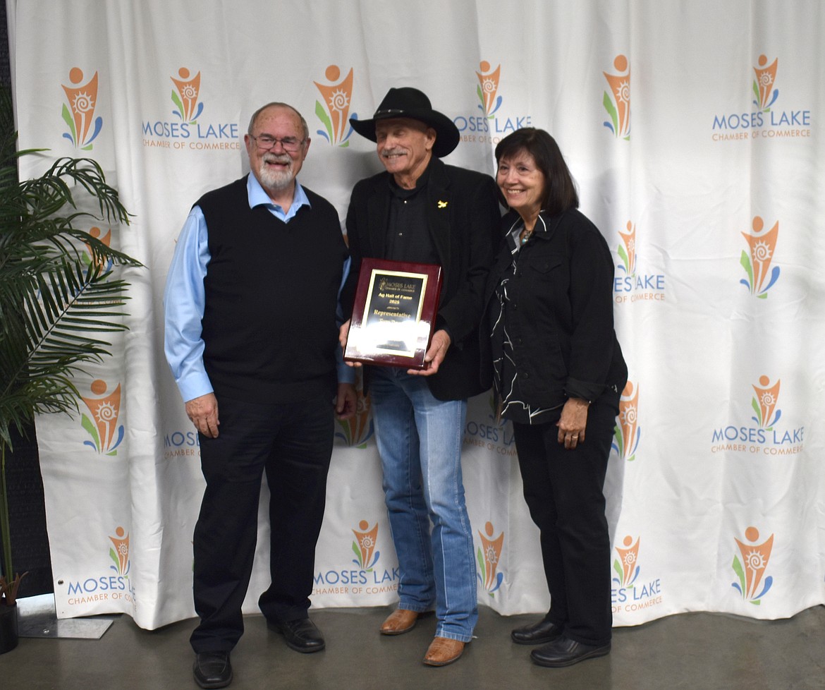 Former state Rep. Gary Chandler, left, presents Tom and Dayna Dent with a plaque commemorating their induction into the Moses Lake Hall of Fame Oct. 21.