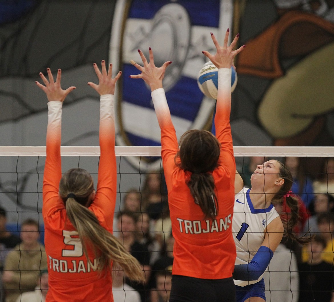 MARK NELKE/Press
Coeur d'Alene senior Kaylee Paulson (1) hits past the block of senior Tiffany Foxx (5) and junior Reese DeGraw-Tryall (4) of Post Falls in the deciding match of the 6A District 1 volleyball championship Saturday at Coeur d'Alene High.