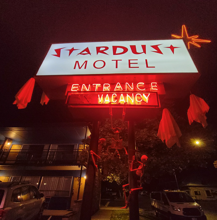 Creepy skeleton decorations scale the Stardust Motel sign in Wallace, adding to the eerie vibe of the Paranormal Festival.
