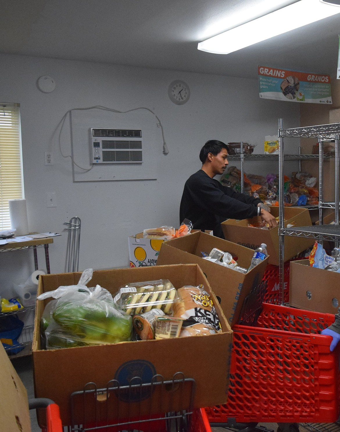 Othello Food Bank volunteers prepare food boxes for customers on Tuesday afternoon. The food bank consistently needs volunteers, according to the executive director.
