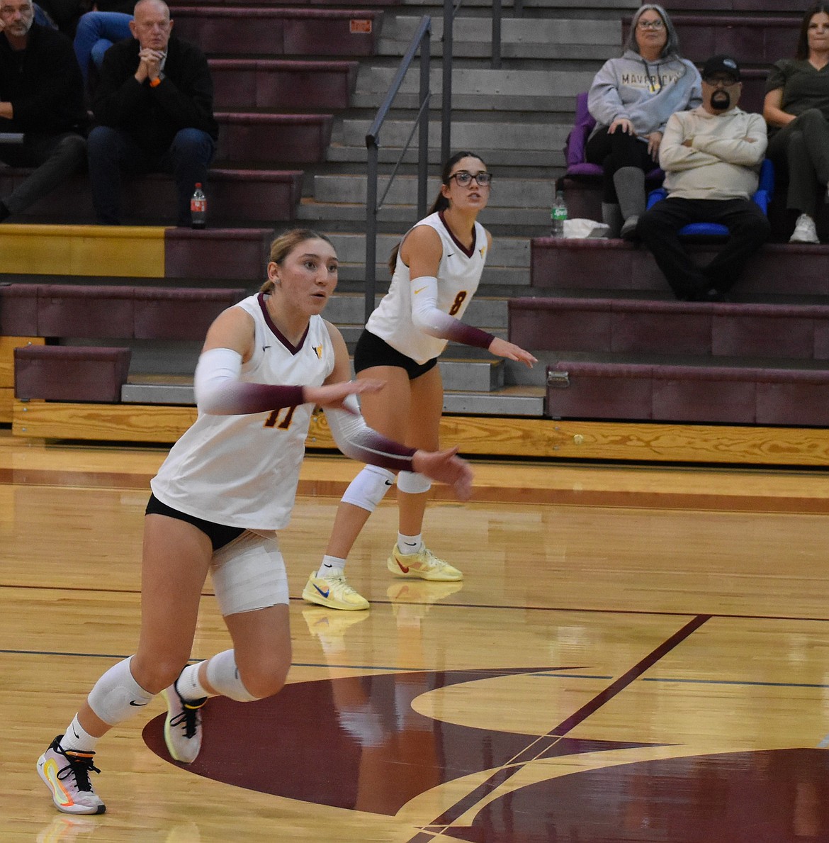 Mavs Kardyn Martinez (11) rushes over toward her teammate Bella Minor (not pictured) who is setting up an assist for Martinez to go for the kill while Caitlin Decubber (8) cheers on her teammates in the background.