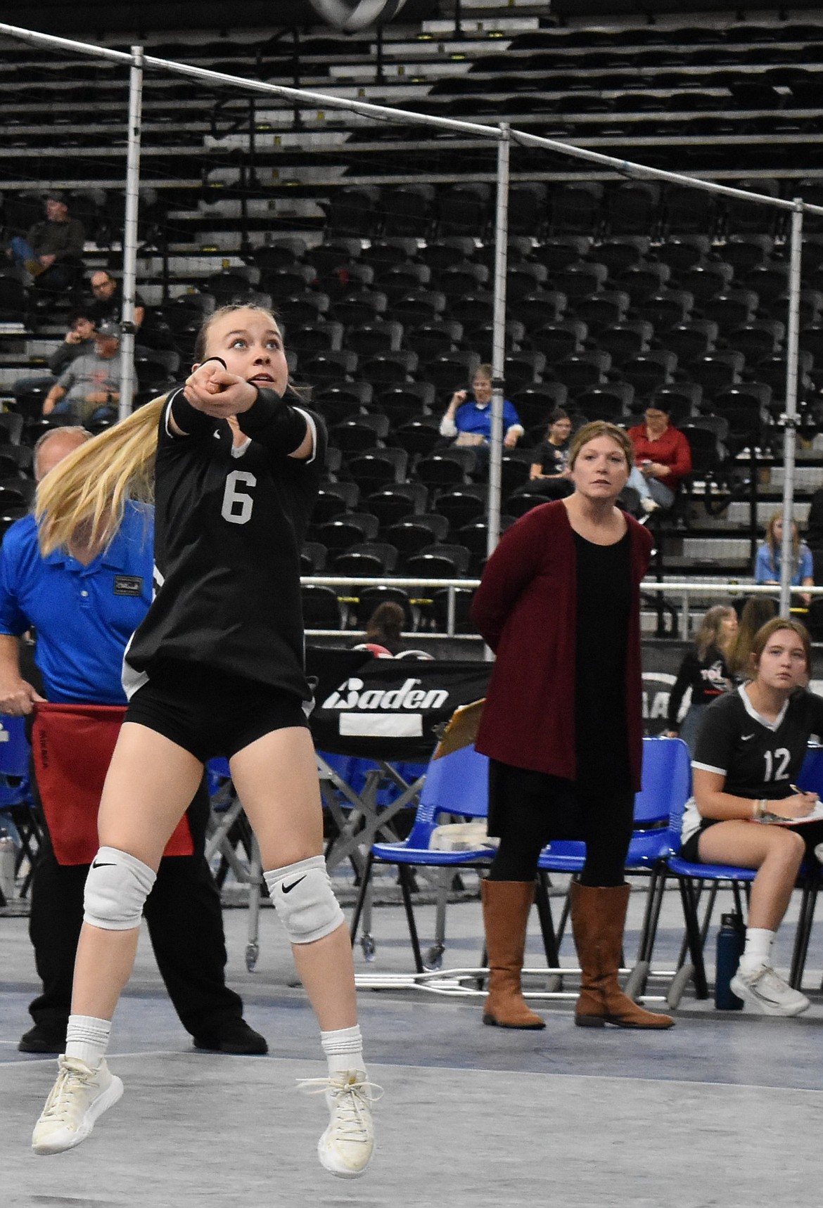 ACH senior Elle Schwartz bumps up the ball after a serve from the opposing Darrington during the second round of the state tournament with head coach Katie Walsh watching from the sideline.