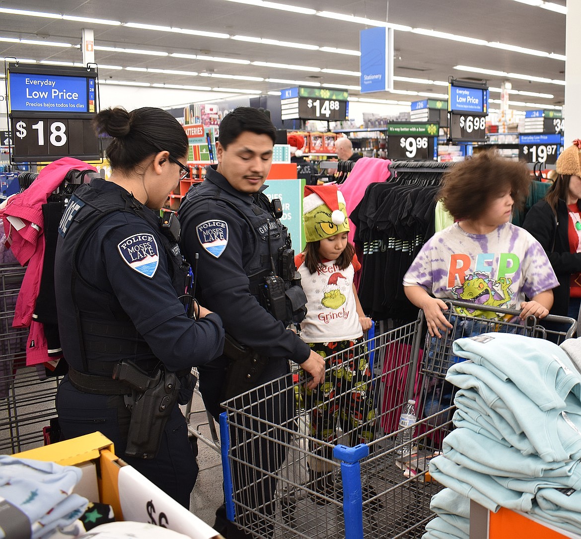 Moses Lake Police Officers Yulisa Zepeda-Lopez and Greg Alvarado help youngsters shop during Shop with a Cop last December. Local law enforcement agencies are ramping up to gather money for this year’s event. Donations may be made at your local police department or sheriff’s office.