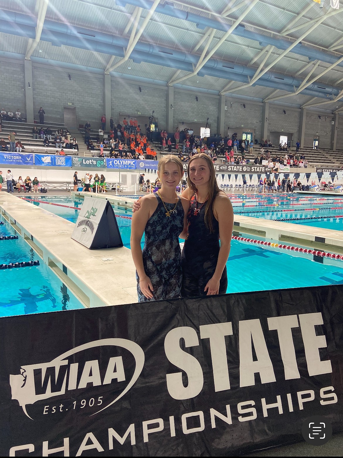 MLHS athletes Dallie Cobb and Bria Bodenman stand together on the side of the pool during the state tournament. The two seniors both had success in their individual events at state.