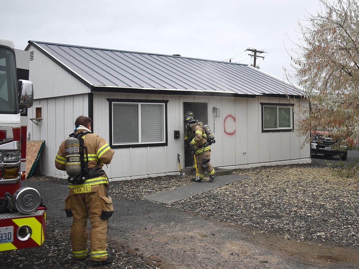 Firefighters from Moses Lake Fire Department’s C Shift enter a house that was donated to them for training purposes Monday.