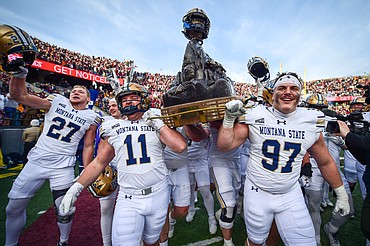 The Bobcats celebrate with the Great Divide Trophy after a 31-28 win over the Grizzlies in the 124th Brawl of the Wild at Washington-Grizzly Stadium on Saturday, Nov. 22. (Casey Kreider/Daily Inter Lake)