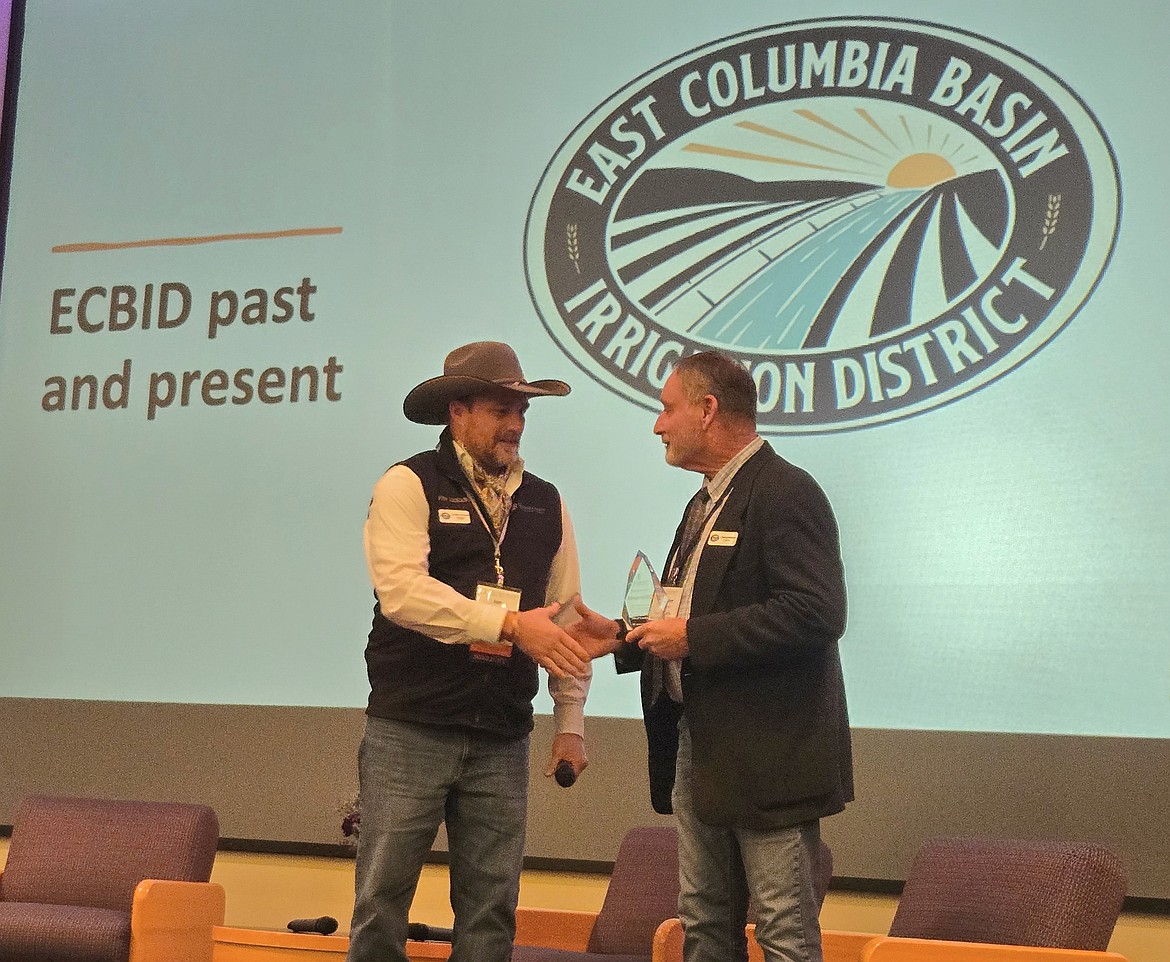 East Columbia Basin Irrigation District board president Duaine Anderson, right, accepts the Columbia Basin Development League’s Perseverance award from CBDL President Jon Erickson.