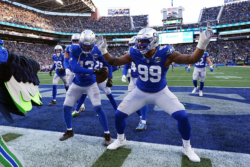 REMOVES ZACH CHARBONNET - Seattle Seahawks linebacker Ernest Jones IV (13) and defensive end Leonard Williams (99) celebrate after an interception by Jones during the second half of an NFL football game against the Minnesota Vikings on Sunday, Nov. 30, 2025, in Seattle.