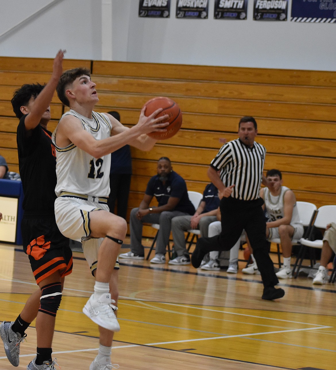 MLCA/CCS junior Treyson Kast makes an attempt at the rim despite pressure from Entiat.