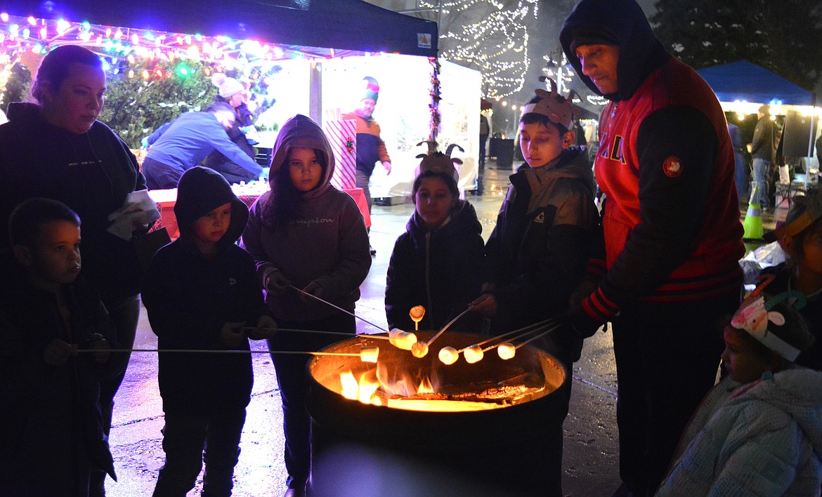 Amanda Evans and Christelle, Garyson and Robby make s'mores alongside Mark Ameerali, Robby, Izzy, Ashleigh, Ben and Zoe at Winterfest in Post Falls.