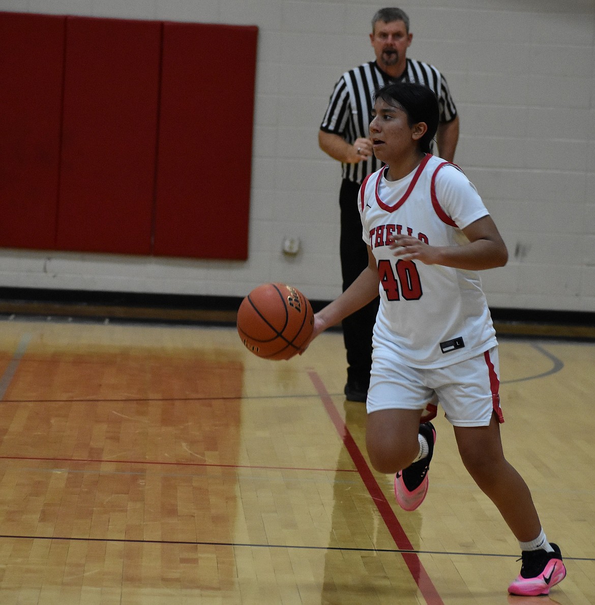 Enyce Perez-Vargas dribbles the ball at the halfway point of the court as she looks for an opportunity to pass to a teammate.