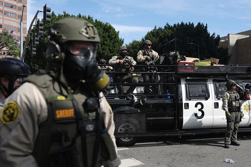 Masked law enforcement officers stand guard during a protest in Los Angeles in June. Washington lawmakers are proposing to make it illegal for law enforcement officers to wear face coverings.