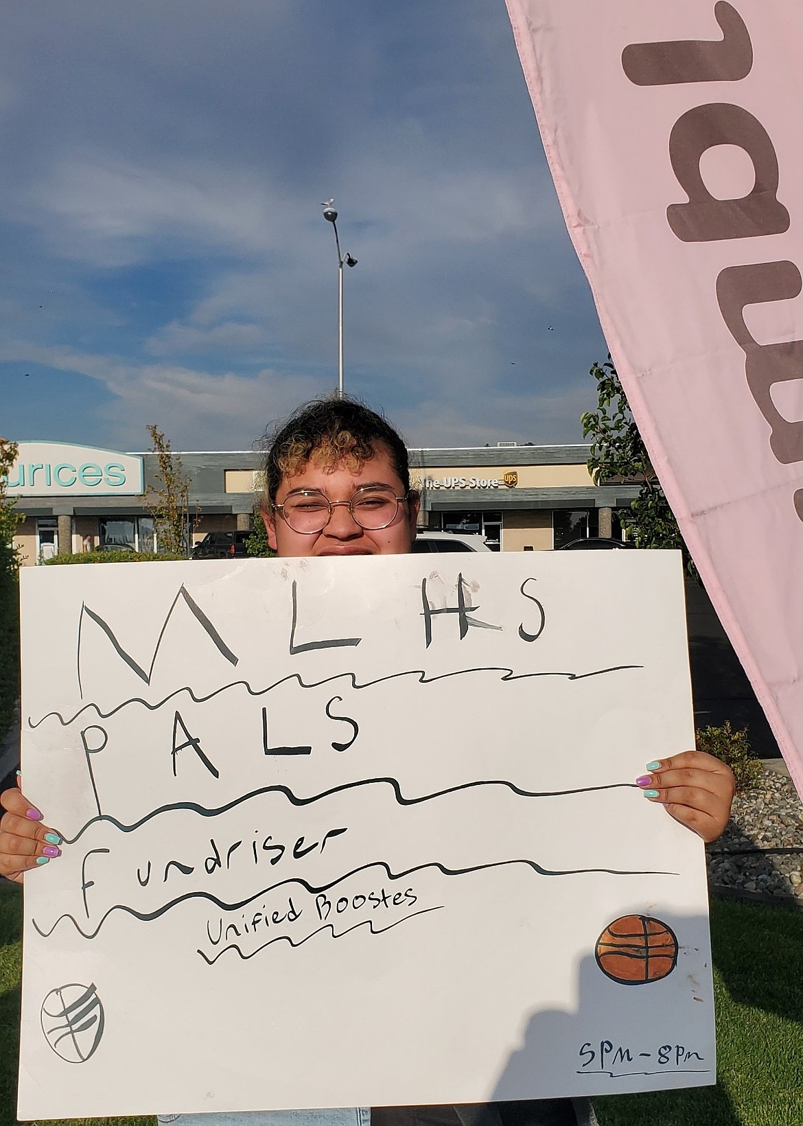 Josline Dominguez-Gomez holds up a sign during the last fundraiser for the Moses Lake Pals Club. This fundraiser will have a winter theme in honor of the season.