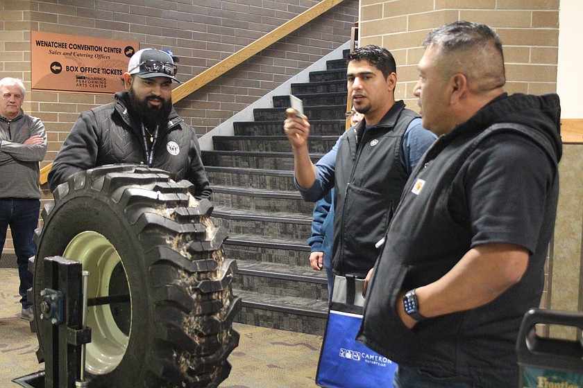 A vendor demonstrates products for attendees at the Washington State Tree Fruit Association annual meeting in Wenatchee.