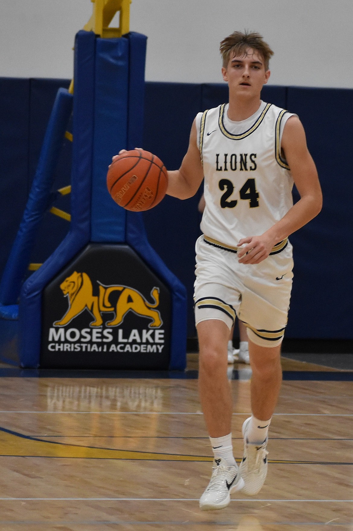 MLCA/CCS senior Johnny Ferguson takes the ball down the court after taking possession of the ball during the first half against the Devils. Ferguson dunked the ball for two and made multiple three-point shots during the game.