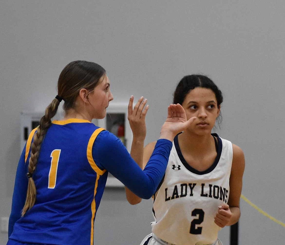 Lions senior James Robertson leaps up to block a shot from Devils player Aiden Valline during Thursday’s matchup. The two teams had a close battle to start the night, but the Lions pulled ahead quickly.
