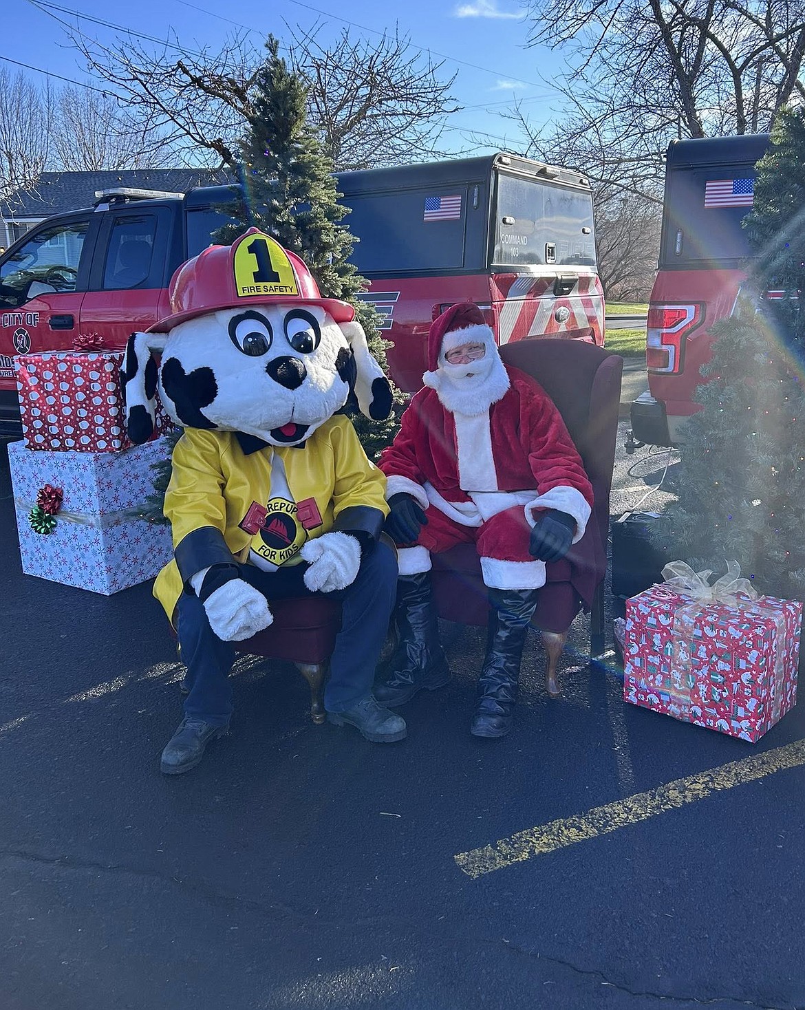 Sparky the MLFD mascot, left, and Santa Claus – sometimes known as retired firefighter Jay Morice – pose for photos at Ashley’s Playground in Moses Lake Saturday.