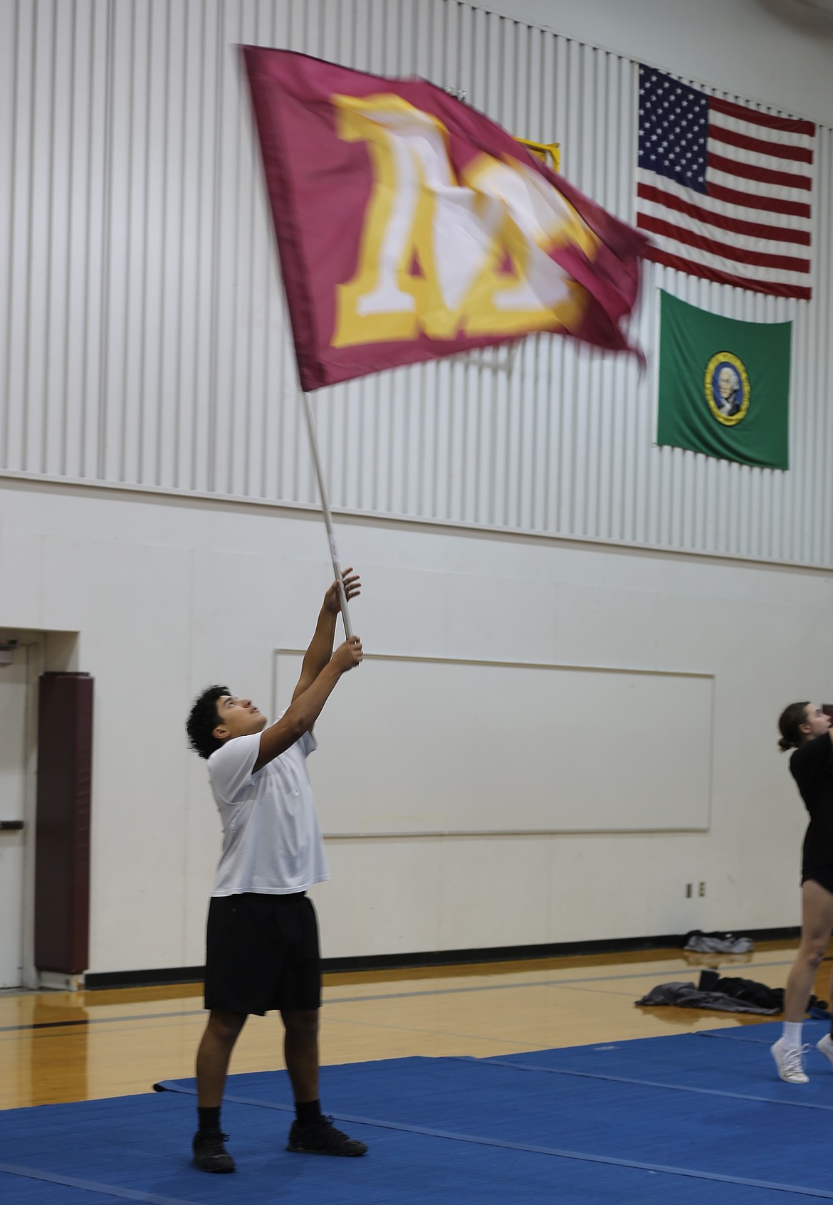 A Mavericks cheerleader waves a ‘M’ flag that helps spell out ‘Mavs’ during their game day routine.