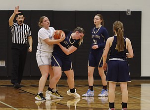 Hannah Brummett, left, and Taylor Starnes, right, joust for control of the ball during their game on Monday. The Almira/Coulee-Hartline Warriors defeated the Moses Lake Christian Academy/Covenant Christian School Lions 61-18.