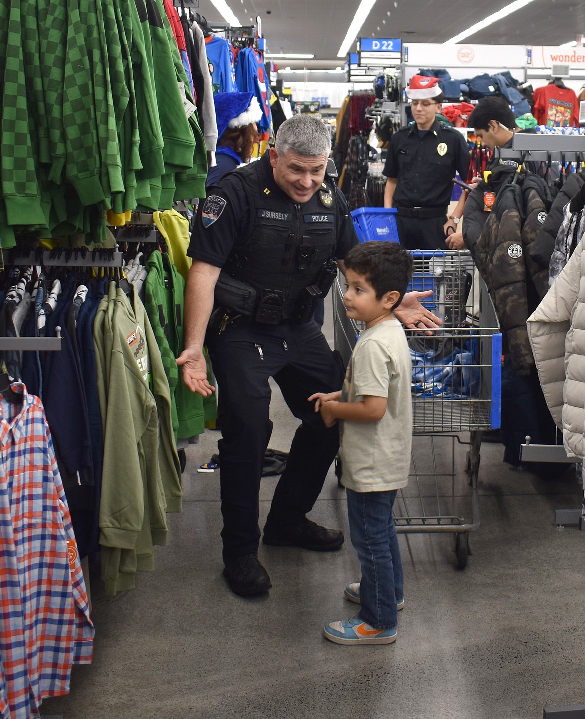 Moses Lake Police Capt. Jeff Sursely – who also serves as the department’s public information officer – checks out clothes with Angel Dominguez of Moses Lake at Shop with a Cop Tuesday.
