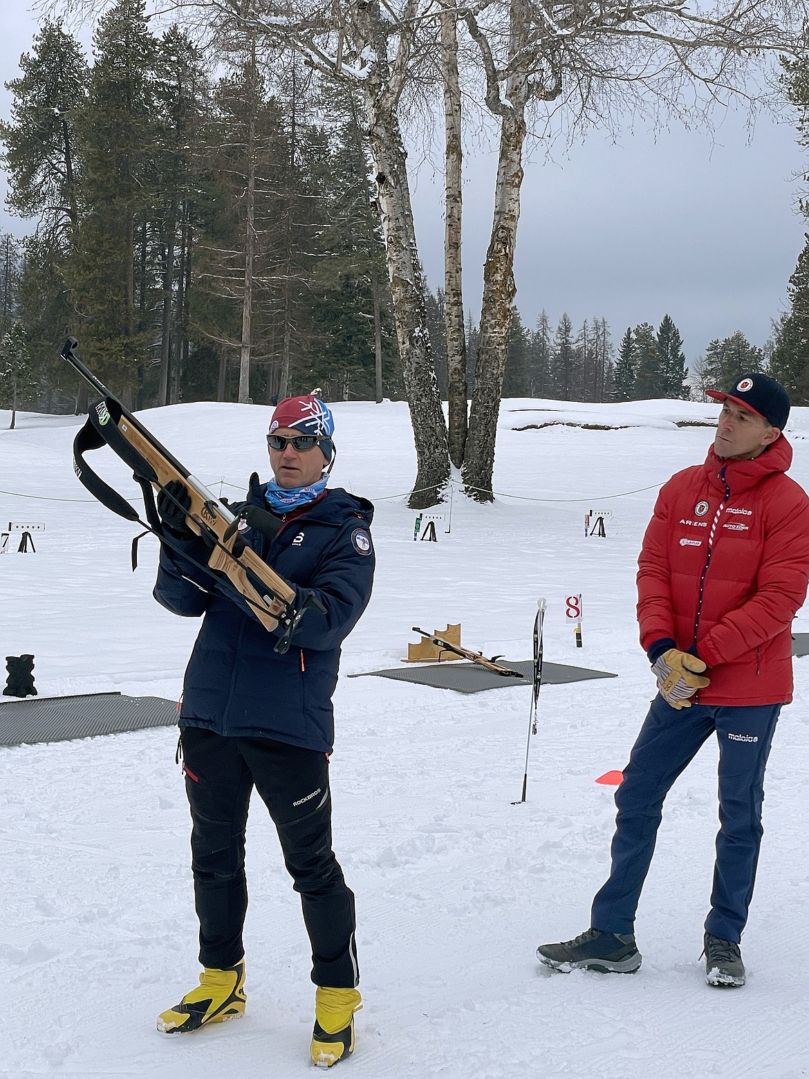 U.S. Biathlon Director of Sport Development, John Farra, (in the red jacket) watches as Glacier Nordic Club coach Ed Visnovske ,with a biathlon laser rifle, runs practice.