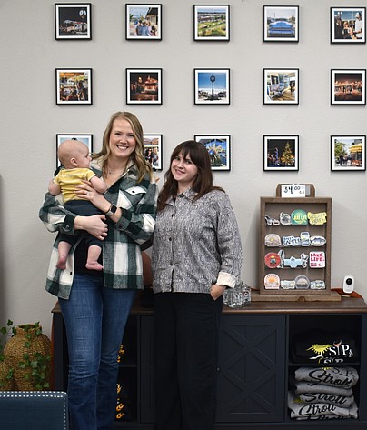Mallory Miller, left, and Sarah Page of the Downtown Moses Lake Association in the organization’s new office on South Division Street. Page came on board as the DMLA’s events coordinator in July, and the little fellow in Miller’s arms came along in August.