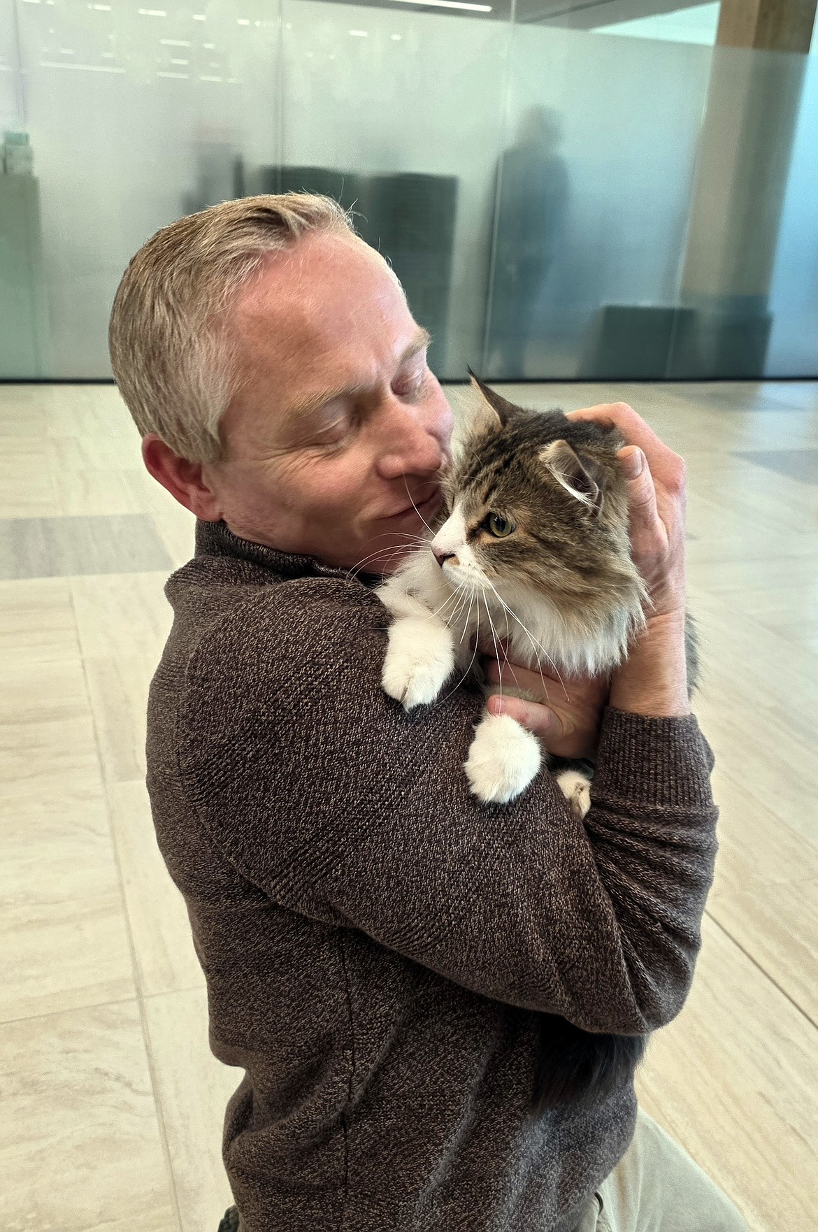 Shannon Haynes flew from Arkansas to be reunited with his cat, Newton, at Glacier Park International Airport Dec. 9 after the cat went missing while camping in mid-September. (Darcy Albert photo)