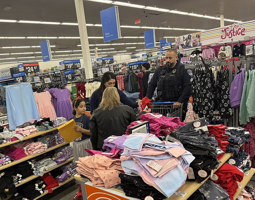 Officer Valdez with the Moses Lake Police Department works with children and parents during this year’s Shop with a Cop event.