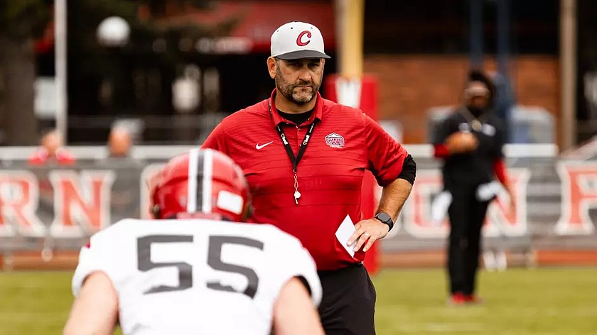 Chris Fisk, red shirt, looks over a drill at the Wildcats football practice. Fisk recently departed the program to take the head coaching job at Portland State University.