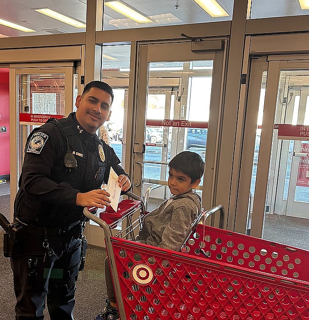 QPD officer Mark Gomez and his shopping partner prepare to set out on a quest for toys. The Quincy Police Department was able to help ten families for Christmas with its Shop with a Cop program.