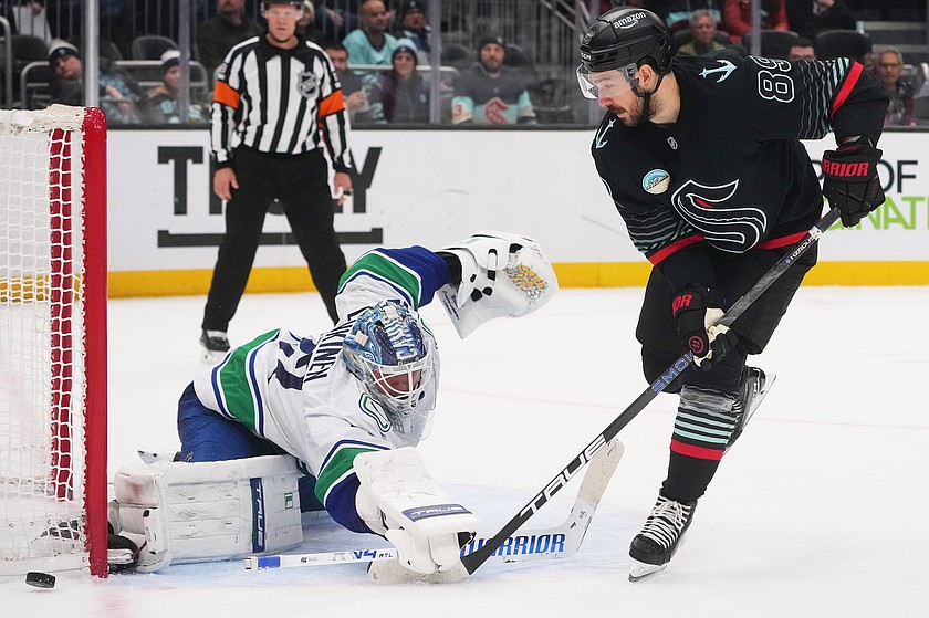 Seattle Kraken center Frederick Gaudreau has his shot blocked by Vancouver Canucks goaltender Kevin Lankinen, left, during a shootout in an NHL hockey game Monday, Dec. 29, 2025, in Seattle.