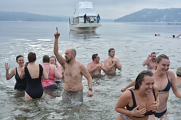 Spectators watch from the beach and a nearby boat as the Polar Bear Plunge gets underway on Lake Coeur d'Alene. Some quickly grew cold after venturing into the water and some were invigorated by the chill.