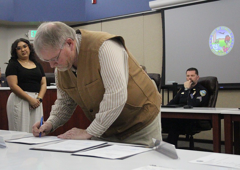 Othello Mayor Ken Johnson signs his oath of office in December. Whether or not Johnson is city administrator as well as mayor was the subject of a discussion at the Othello City Council Monday.