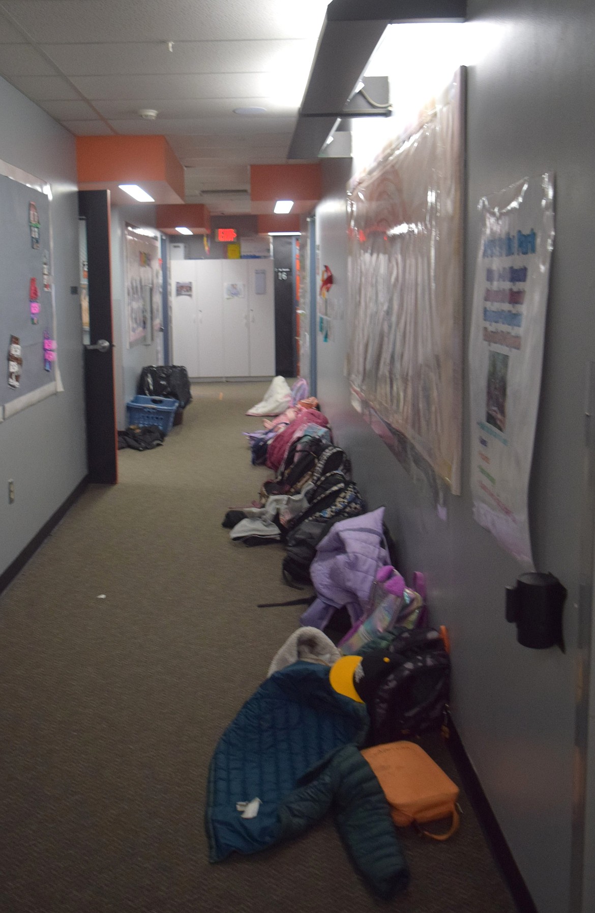 Backpacks line the hallway at Grant Elementary. However, when it rains, buckets take over the hallways, catching rainwater seeping through the roof.